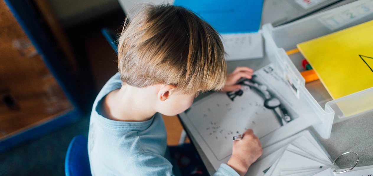 Photo of a young child working on a school project at the Haring Center