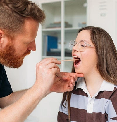 Photo: Clinician performing an exam on a patient with Down Syndrome.