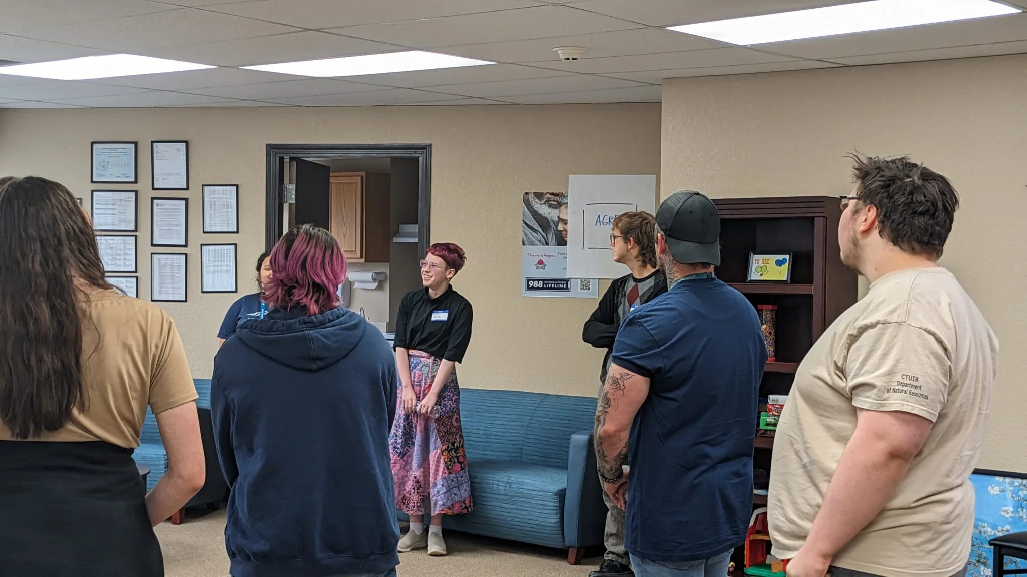 Teenagers and young adults stand in a group discussion