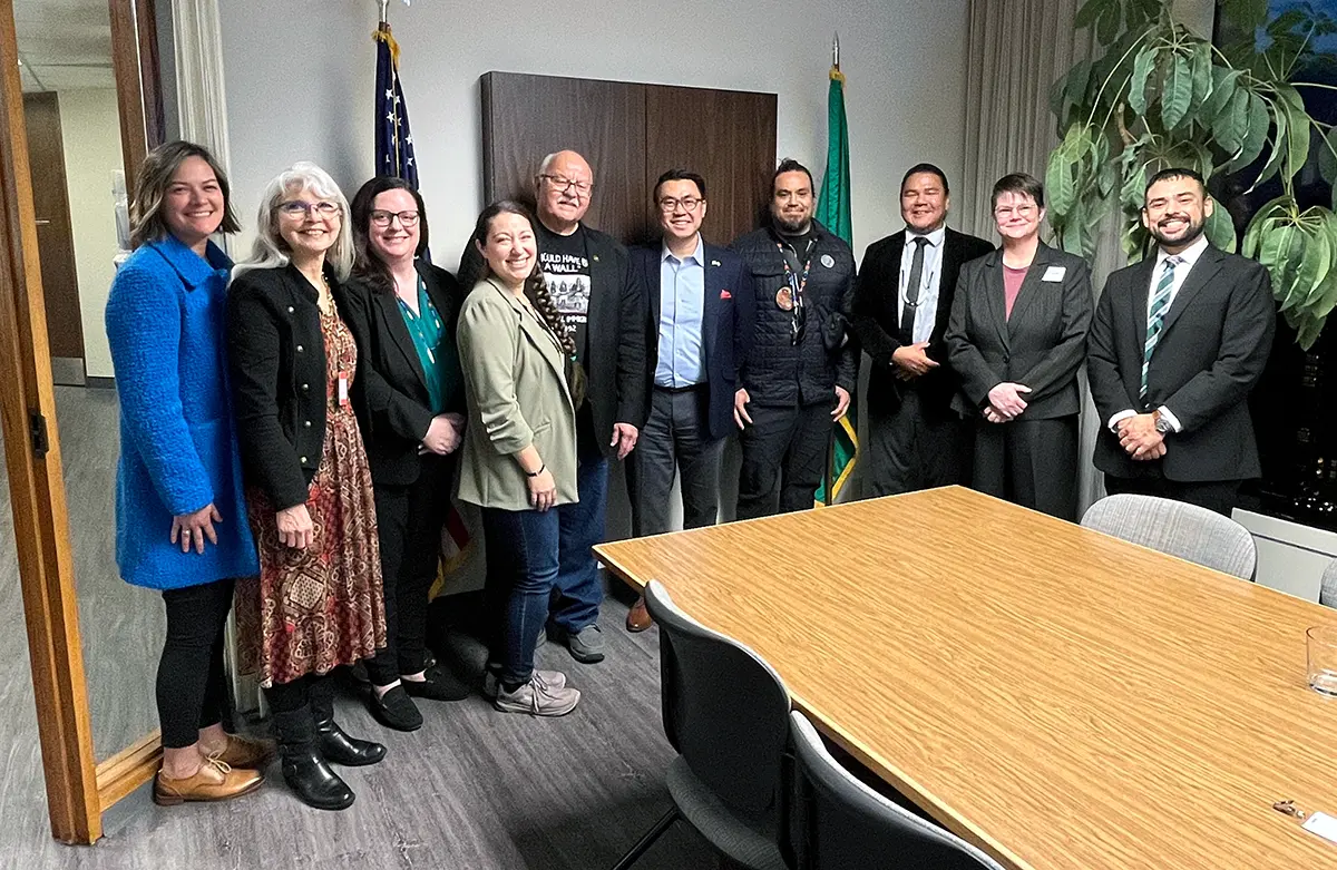 A group of people pose for a photo in an office.