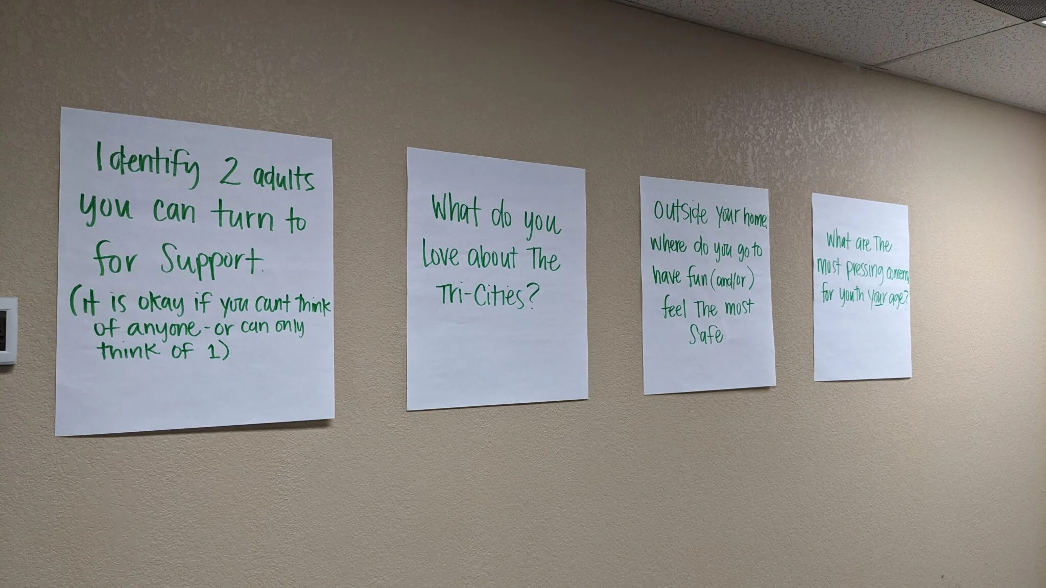 Posters on a wall with prompts for session participants to respond to