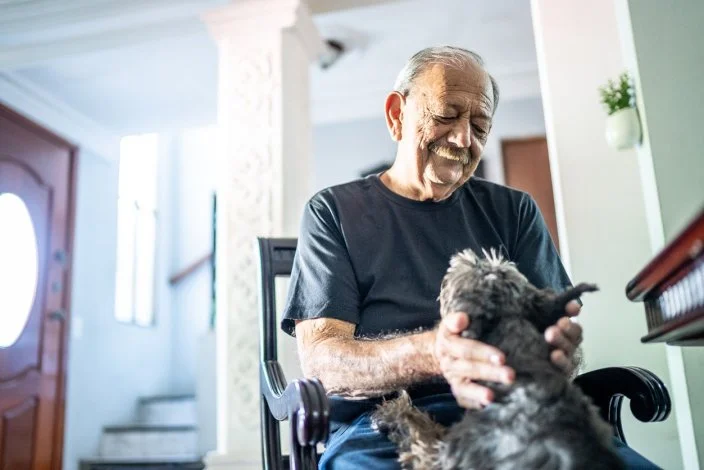 Senior man playing with dog at home
