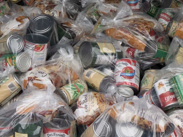 Food cans of Thanksgiving essentials are stacked in the trunk of a car in pre-packaged clear bags ready to be gifted to Veterans.