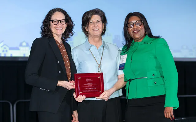 City Manager Diane Carlson (left), Mayor Lynne Robinson (center) and HDC executive director Patience Malaba pose with the 2025 award.